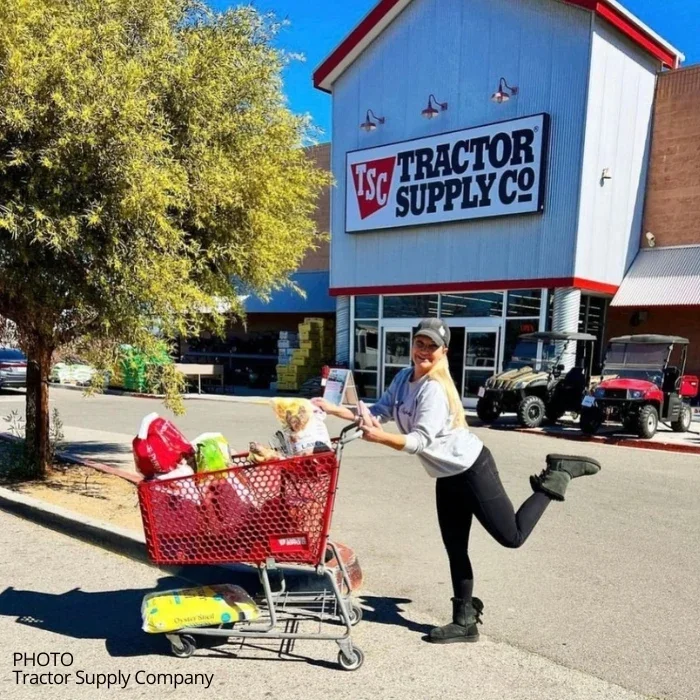 A shopper pushing a cart in front of a Tractor Supply Co. store