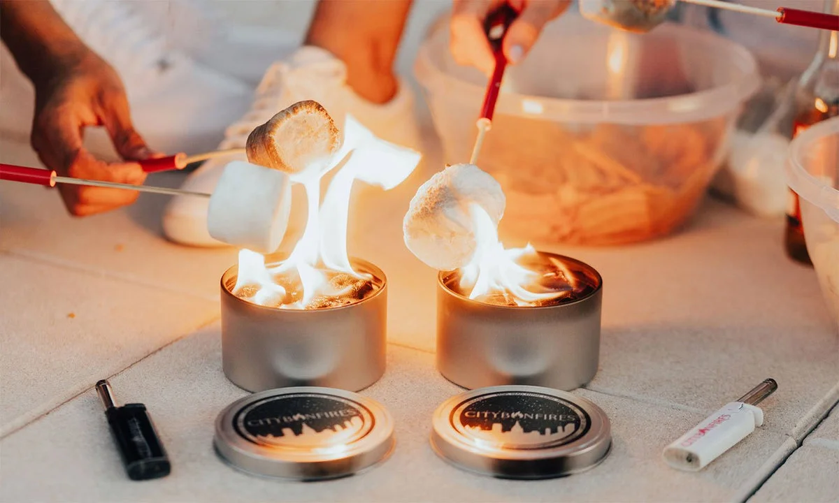 Two lit City Bonfires with marshmallows being roasted
